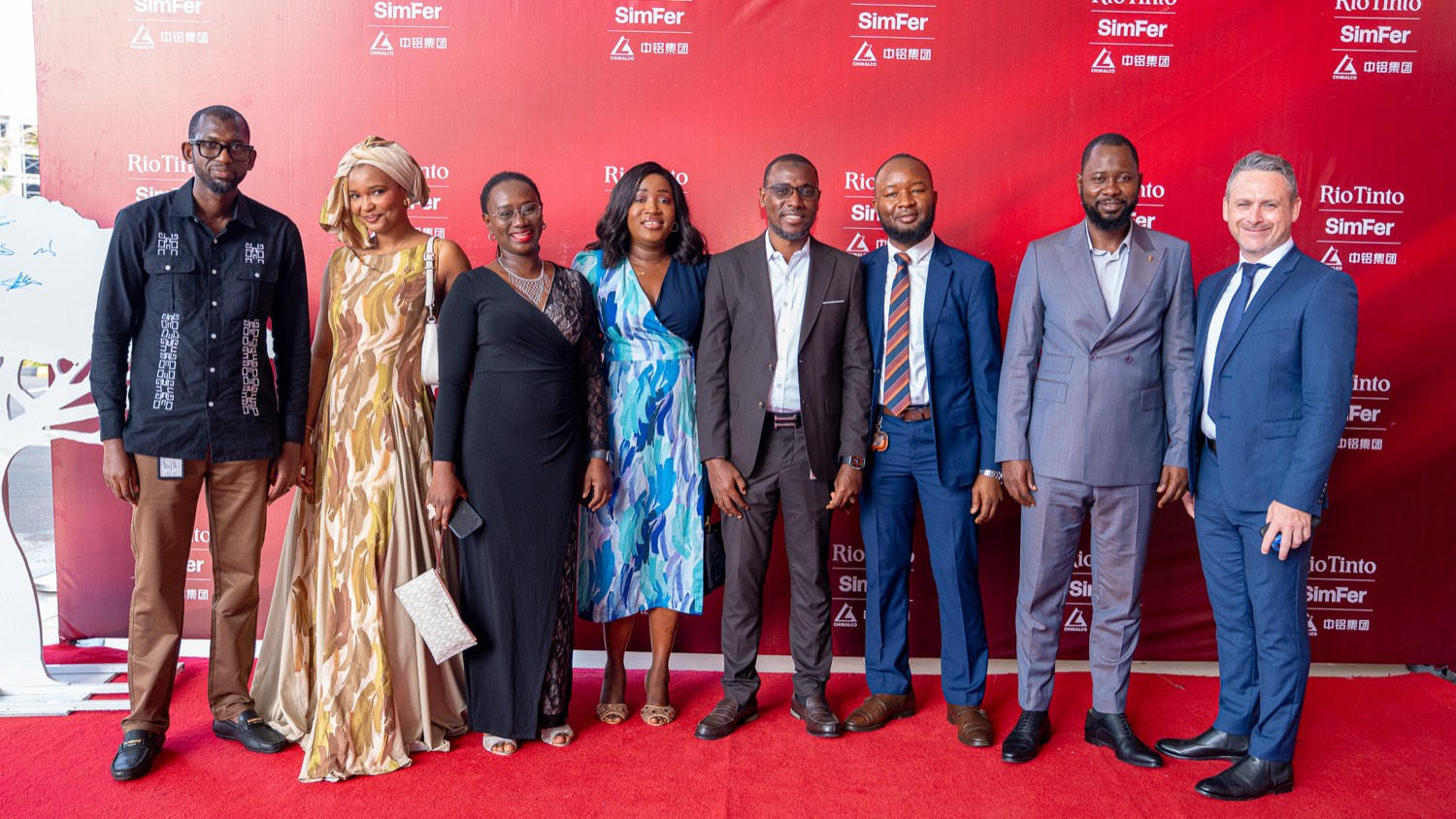 Photo de groupe des huit lauréats des prix fournisseurs 2026 devant un fond aux couleurs de Rio Tinto et SimFer, lors de la cérémonie à Conakry.